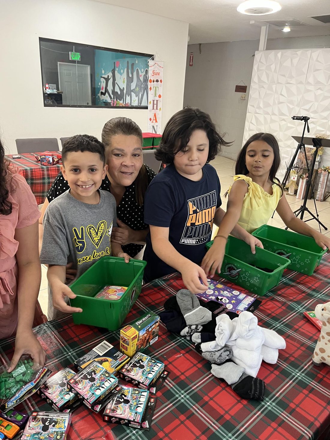 La pastora Teresita y varios niños de la iglesia llenando cajas de Operation Christmas Child con juguetes, ropa y útiles